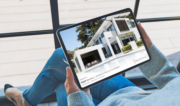 A person holding a tablet displaying a high end real estate listing